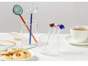 Gedetailleerd uitzicht op creatieve gekleurde transparante glazen lepels voor koffie en melk.