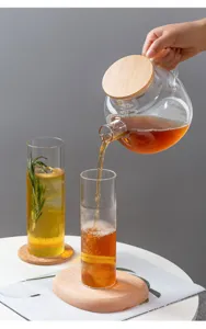 Detailaufnahme des hitzebeständigen Glas Bechers mit Holzuntersetzer für erfrischende Getränke.