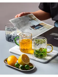 Tazza d'acqua in vetro martellato con manico colorato, design elegante per casa e caffè.