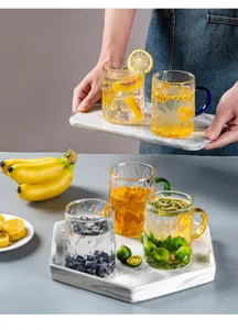 Squisita tazza di vetro con manico colorato e corpo strutturato per bevande quotidiane.
