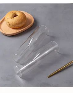 Set di bicchieri da champagne in vetro a doppia parete con vassoio in legno e dettaglio.