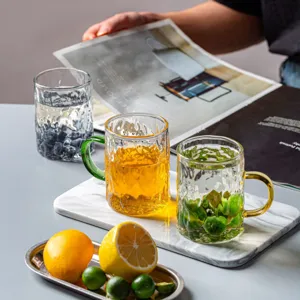 Tazza da caffè in vetro trasparente con manico colorato, elegante bicchiere strutturato per casa.