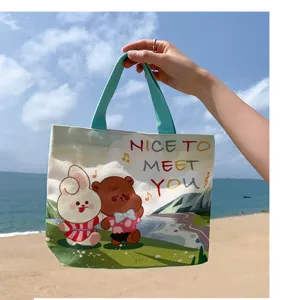 Close-up of cute canvas tote bag with bunny and bear print, casual outdoor beach style design.