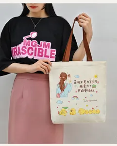 Detailansicht der lässigen Canvas-Tasche mit süßem Cartoon-Druck und braunen Henkeln.