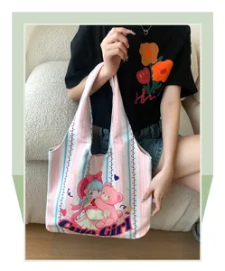 Close-up detail of a cute cartoon printed canvas tote bag, featuring stylish pink stripe design.