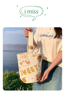 Canvas bucket bag with wooden handle, cute cartoon print and large capacity for daily commute.