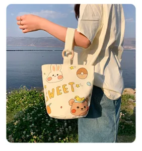 Cute canvas bucket bag detail showing sweet cartoon prints and unique wooden ring handle.