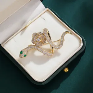 Detailed close-up view of a stunning gold snake and rose brooch adorned with sparkling crystals.