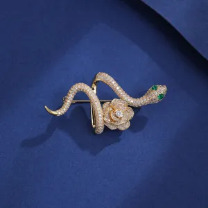 Exquisite gold snake and rose brooch with dazzling rhinestones and green eyes.