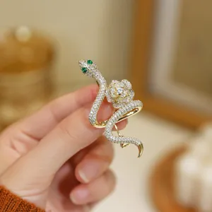 Detailed close-up of a glamorous rhinestone snake and rose brooch pin style