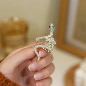 Exquisite rhinestone snake and rose brooch featuring sparkling crystal accents and green eyes.