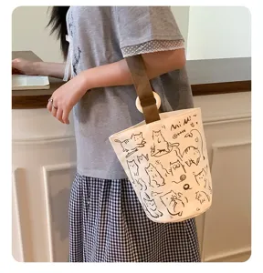Borsa a secchiello in tela con simpatici stampi di gatti cartoni animati e manico in legno per uso.