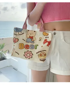 Detailed view of a cute cartoon bear canvas tote bag with pink straps for daily commuting.