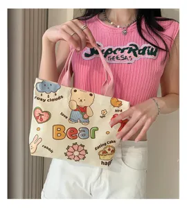 Detailed view of the cute cartoon canvas tote bag showing adorable bear print and handles.