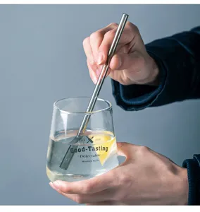 Detailed view of clear glass cup and straw with modern style text and lemon slice inside.