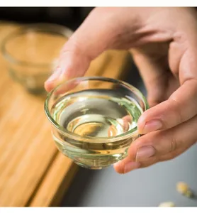 Primo piano dettagliato di una tazza da tè in vetro trasparente con liquido chiaro.