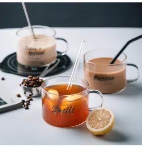 Tazza in vetro trasparente con manico e stampa di lettere per caffe e bevande in ufficio.