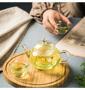 Set da tè in vetro resistente al calore con infusore, tazzine trasparenti e vassoio.