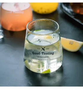 Primo piano di tazza in vetro trasparente con elegante tipografia nera e consistenza.
