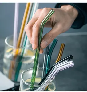 Close-up detail of colorful bent glass straws in a glass cup, smooth and transparent.
