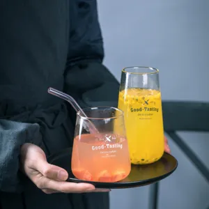 Bicchiere in vetro minimalista con stampa di lettere, ideale per bevande fredde e smoothie.