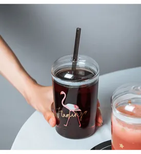 Nahaufnahme des hitzebeständigen Glasbechers mit Flamingo-Motiv, Deckel und Strohhalm.