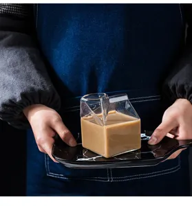 Detailopname van een creatieve melkkartonvormige glazen bekers met een lekkere drank.