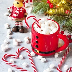 Festieve rode kerstman keramieken koffiekop met zoete zuurstokken en zachte marshmallow traktatie.