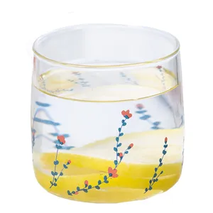 Clear glass cup with cute floral pattern and lemon slices for daily water and milk breakfast.