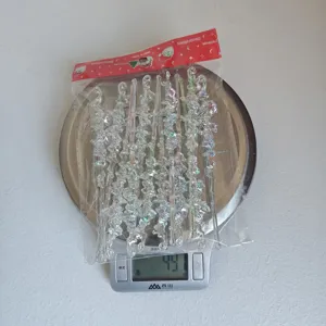 Vue détaillée de décorations de Noël en glaçons acryliques iridescents sur une balance.