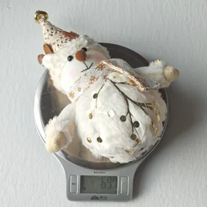 Detailed view of Christmas plush deer toy lying on kitchen scale, festive holiday decor.