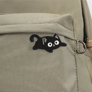 Detailweergave van het zwarte kat metaal speldje, perfect accessoire voor een rugzak.