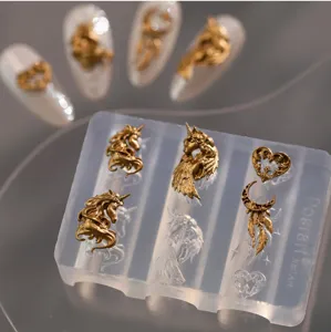 Primer plano de molde de silicona para uñas con unicornio dorado y piezas de resina.
