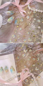 Nahaufnahme von Meeres-Nagelstickern mit goldgeprägten Muscheln und Seepferdchen.