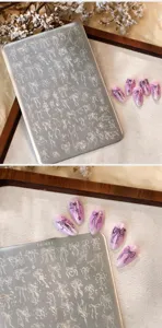 Close-up detail of stainless steel nail art stamping plate with intricate bow patterns