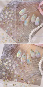 Detailansicht von Goldfolien-Nagelstickern mit Meeresmotiven wie Muscheln und Seesternen.