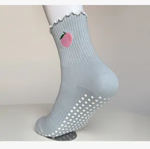 Non-slip yoga socks with silicone grips and cute peach embroidery, perfect for indoor fitness and pilates.