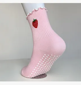 Pink women's non-slip yoga socks with cute strawberry embroidery and rubber grip soles.