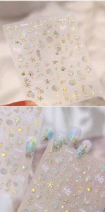 Detailansicht von Meeres-Nagelstickern mit holografischen Goldfolien-Muscheln und Seesternen