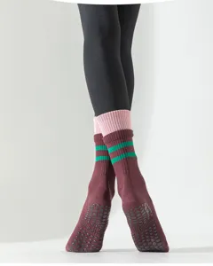 Gros plan sur des chaussettes de yoga antidérapantes à rayures vertes et semelle en silicone.