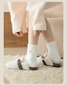 Cozy plush women mid-tube socks with cute heart embroidery and fuzzy slip-on clogs.