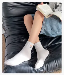 Comfortable white cotton mid-tube socks for women featuring cute cartoon dog embroidery.