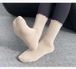 Women's mid-calf yoga socks with non-slip grip soles and cute ruffle cuffs for pilates fitness.