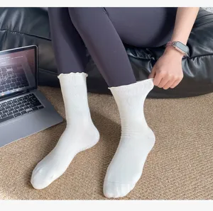White women's mid-calf yoga socks with cute ruffled edges and anti-slip grip for fitness.