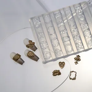 Detailopname van een transparante siliconen nagelmal met metalen nageldecoraties.