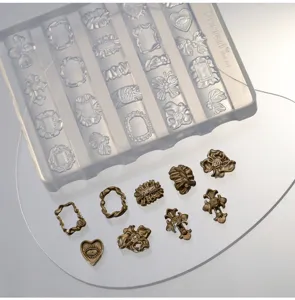 Detailopname van een transparante siliconen nagelvorm met afgewerkte metalen versieringen.