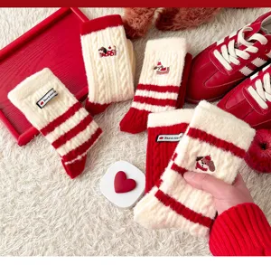 Cozy thick red winter socks detail shot, cute dog embroidery, festive holiday home wear.