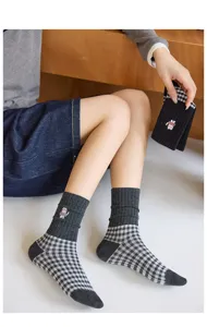 Vue détaillée de chaussettes écossaises grises pour femmes avec broderie d'ours et bords côtes.