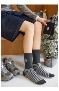 Détail des chaussettes d'hiver pour femmes avec motif à carreaux gris et broderie de chat.