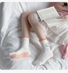 Damen Anti-Rutsch Yoga Socken mit orangen Grip-Noppen und Rüschenbündchen für Fitnesstraining.